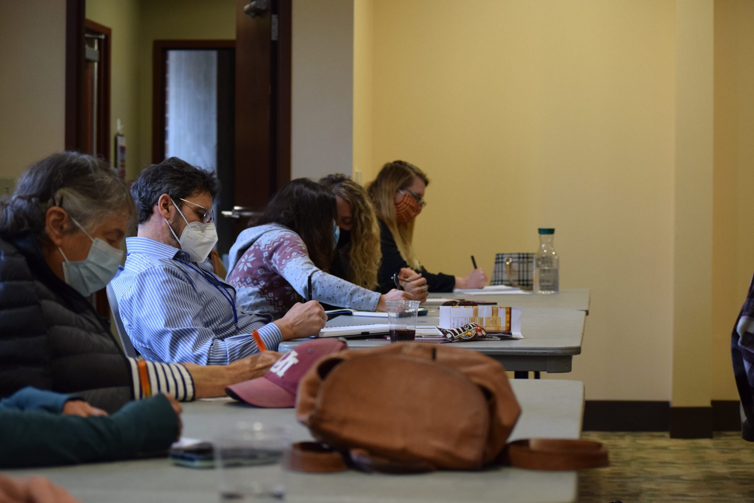 people seated at tables doing a writing exercise